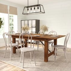 a dining room table with six chairs and a light fixture hanging over it's head