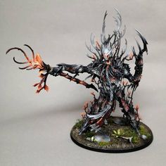 a painted warhammer with horns and flames on it's body, standing in front of a white background