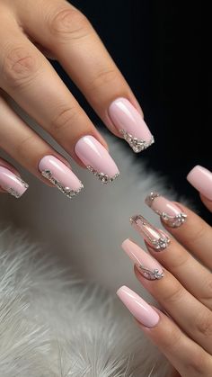 a woman's hand with pink and silver nail polishes on her nails, while she