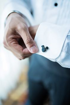 a close up of a person wearing a white shirt and black pants holding his hand out