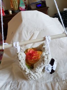 a crocheted object hanging from a rope on a bed