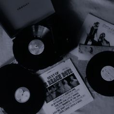 an assortment of records and cds on a bed