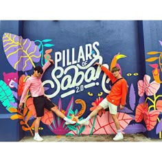 two young men standing in front of a colorful wall with the words pillars of sapa on it