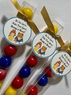 three lollipops with labels on them sitting next to each other in front of a yellow ribbon