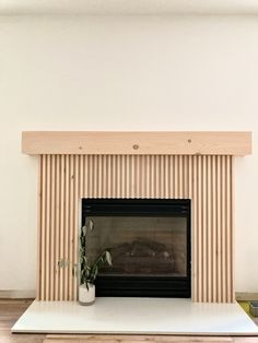 a living room with a fire place and wooden slats on the wall behind it