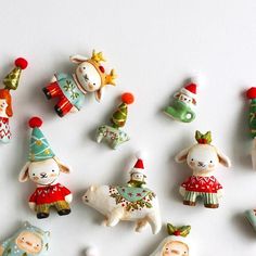 small christmas figurines are arranged on a white surface