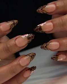 These nails feature a nude base with intricate cheetah print stripes and delicate pink flowers, evoking the wild and vibrant essence of summer safaris.  🌸Click on the image to shop our trending Korean Gel Polish this season.  🌸Credit: chibimoon.nails on Instagram 🌸summer nails, Korean gel polish, tiger nails, floral nails, trending nails, summer manicure, pink flower nails, nude base nails, animal print nails, summer nail trends, Korean nail trends, gel polish manicure, summer nail inspiration, floral summer nails, trendy summer nails, safari nails, pink and brown nails, nail art ideas, summer gel nails, Instagram nail art Safari Nails, Bright Acrylic Nails, December Hair, Tiger Nails, Cheetah Print Nails, Cheetah Nails, Asian Nails