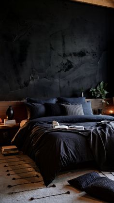 a bedroom with black walls and dark bedding