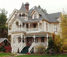 an old victorian style house with white trim and balconies on the second story