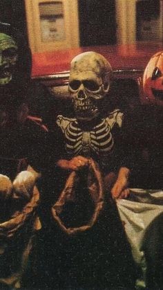 two skeletons sitting next to each other in front of pumpkins and jack - o'- lanterns