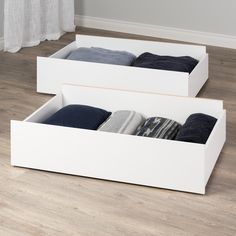 two white boxes with socks in them on the floor