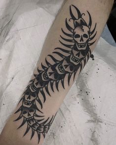 a man's arm with a tattoo design on it and a skull in the middle