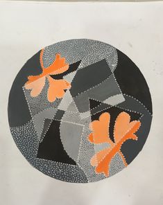 an orange and black circular painting on white paper with circles in the middle that have different shapes