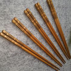 six wooden chopsticks with designs on them