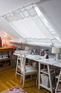 an attic office with lots of clutter on the desk