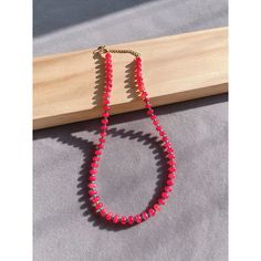 This is a beautiful necklace, made of natural stone. The beads on the necklace show a bright red, shiny surface, reflecting brilliant colors. Each bead has been carefully polished to maintain a consistent size and shape, making the whole necklace look very neat and beautiful. The chain link of the necklace is made of gold metal material, with a small heart decoration, adding a sense of sophistication and romance. The design of this necklace is simple yet stylish, which is perfect for wearing a v Red Single Strand Crystal Necklace With Round Beads, Red Crystal Necklace With Single Strand Round Beads, Red Pearl Necklace With Gemstone Beads, Red Crystal Necklaces With Colorful Round Beads, Red Oval Beaded Single Strand Necklace, Red Pearl Necklace With Polished Round Beads, Red Polished Pearl Necklace, Red Necklaces With Polished Oval Beads, Stone Beaded Necklace