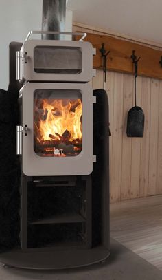 a stove that is sitting in the middle of a room with wood burning on it