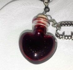 a heart shaped bottle with a chain attached to it