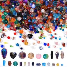 many different colored glass beads on a white surface