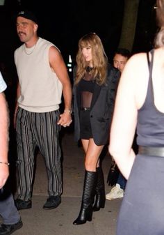 a man and woman walking down the street at night