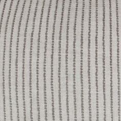 a close up view of a white and grey striped pillow