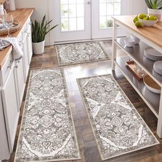 three rugs in the middle of a kitchen with plates and bowls on the counter