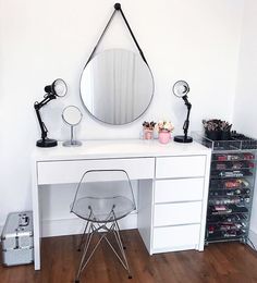 a white desk with a mirror, chair and other items on it in a room