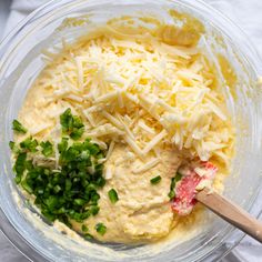 the ingredients for this dip are mixed together in a glass bowl with a wooden spoon