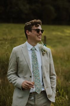 a man in a suit and tie standing in the grass