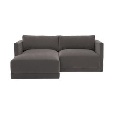 a large gray couch sitting on top of a white floor next to a small ottoman