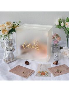 a table topped with cards and vases filled with flowers