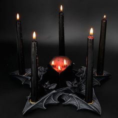 a group of candles sitting on top of a black table next to some sort of candle holder