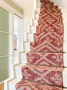 a stair case with red carpet on it