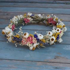 a wreath made out of dried flowers sitting on top of a wooden floor