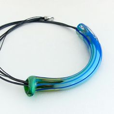 a blue and green necklace on a black cord