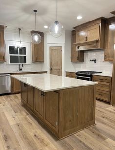 a large kitchen with wooden cabinets and white counter tops, along with stainless steel appliances