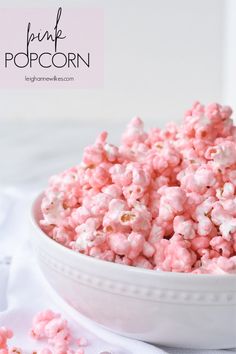 pink popcorn in a white bowl on a table