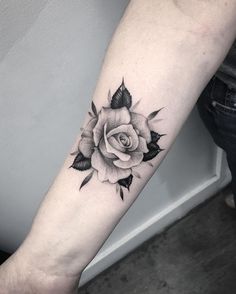 a black and white rose tattoo on the arm