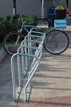 two bicycles are locked to the side of a bike rack in front of a building