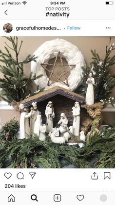 a nativity scene is displayed in front of a christmas tree