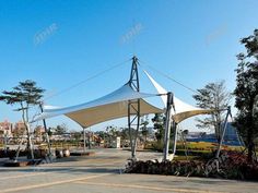 a large white tent sitting in the middle of a park