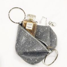 The Ellie Crystal Bag features a roomy crystal mesh pouch and is topped with two metal ring handles. Just slide them over your wrists like bangles to go hands-free. Approx w18cm x h18cm x d15cm Metallic rings approx d8cm Crystal Mesh Zipper closure Two metal ring handles Fits a large smart phone Silver Party Bag With Round Handle, Silver Handheld Clutch For Everyday Use, Party Evening Bag With Removable Pouch And Round Handle, Ring Handle Bag, Mesh Pouch, Crystal Bags, Ring Handle, Chanel Paris, Metal Ring