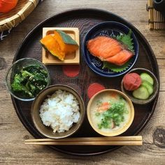 a plate with sushi and chopsticks on it, along with other foods