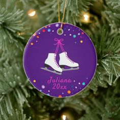 a personalized ornament hanging from a christmas tree with ice skates on it