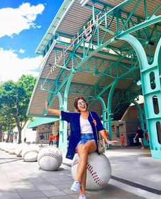 a woman sitting on top of a baseball ball