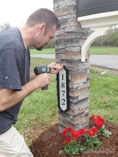 a man is drilling the numbers on a brick column with drillers and hammers