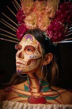 a woman with face paint and flowers on her head