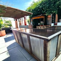 an outdoor bar made out of metal and wood