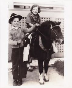 two children are standing next to a horse