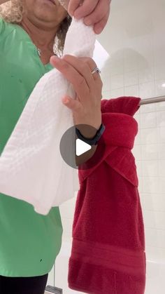 an older woman is brushing her teeth in front of the bathroom mirror while wearing a green sweater